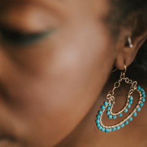 Custom healing turquoise double horseshoe earrings by Justicia Jewelry on model