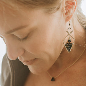 Custom healing moon earrings from Justicia Jewelry with black spinel on model