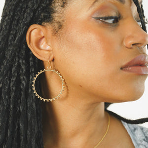 Custom healing Golden Orb Hoop earrings from Justicia Jewelry on model