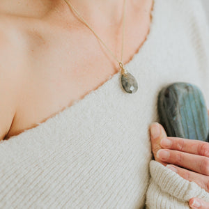 Miracle Magnet Necklace with labradorite and 14k gold fill by Justicia Jewelry on model holding a labradorite stone